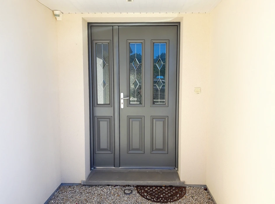 Entrée extérieure d'un bâtiment résidentiel avec porte d'entrée double battant en PVC ou composite gris anthracite