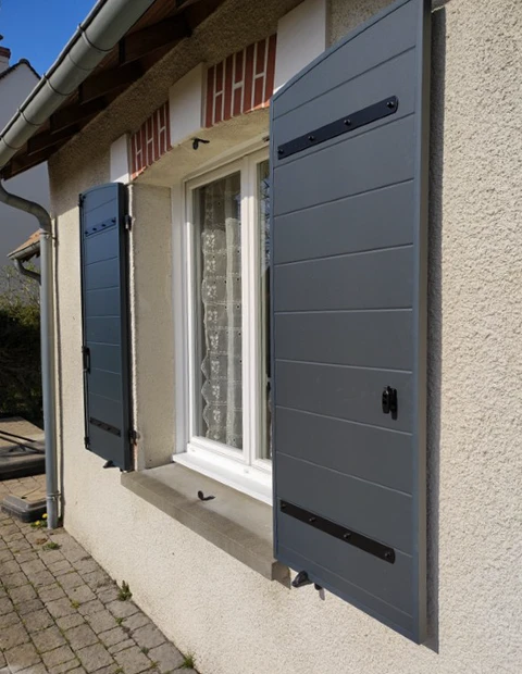 Façade extérieure d'une maison résidentielle avec fenêtre à volets battants gris anthracite ouverts