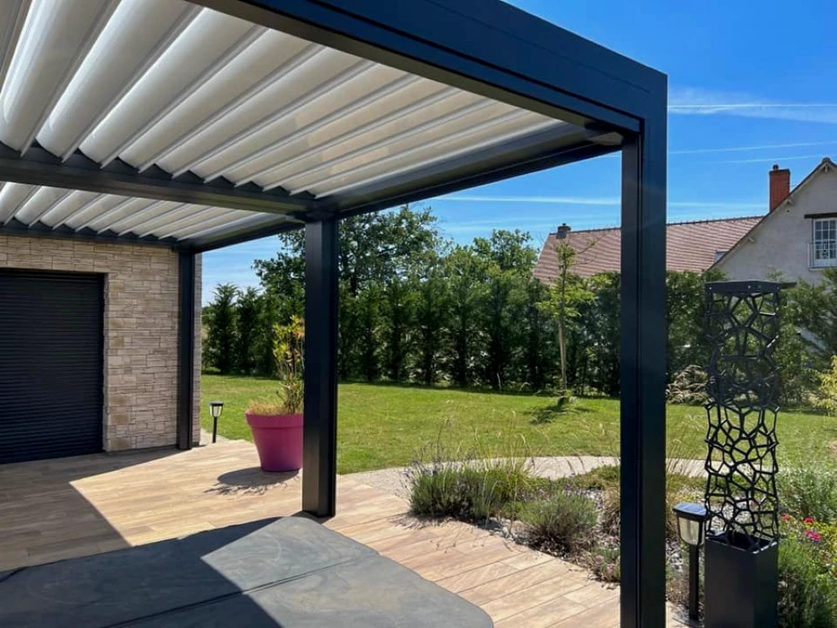 Terrasse extérieure résidentielle avec pergola bioclimatique à lames orientables blanches et structure aluminium anthracite