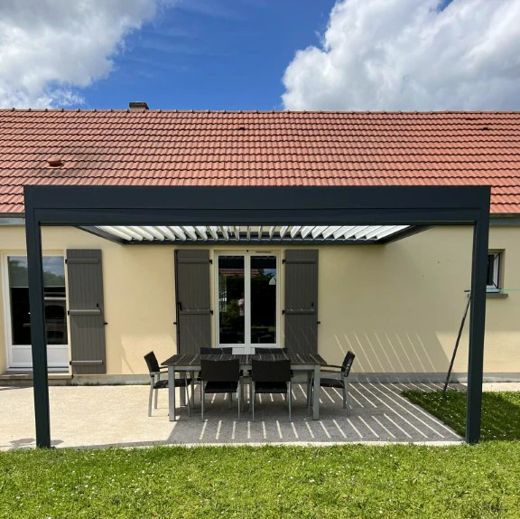 Terrasse extérieure d'une maison individuelle avec pergola bioclimatique à lames orientables en aluminium anthracite