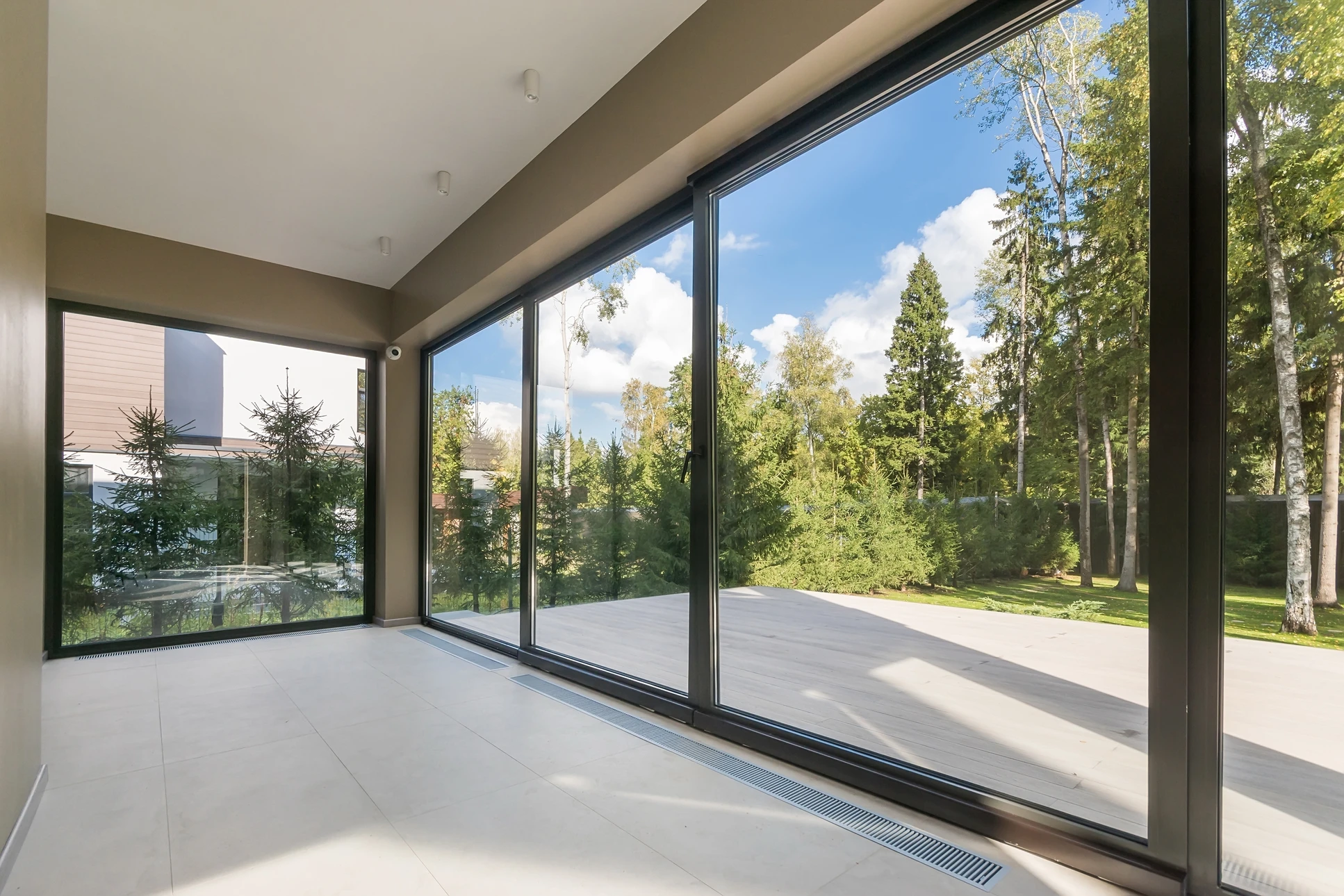 Technicien en gants de protection blancs effectuant une réparation de fenêtre PVC avec tournevis à manche vert translucide