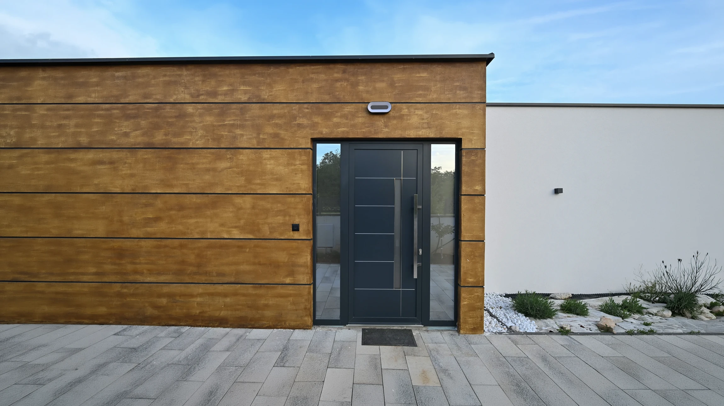 Artisan menuisier en salopette bleue installant une porte intérieure en bois clair avec inserts vitrés