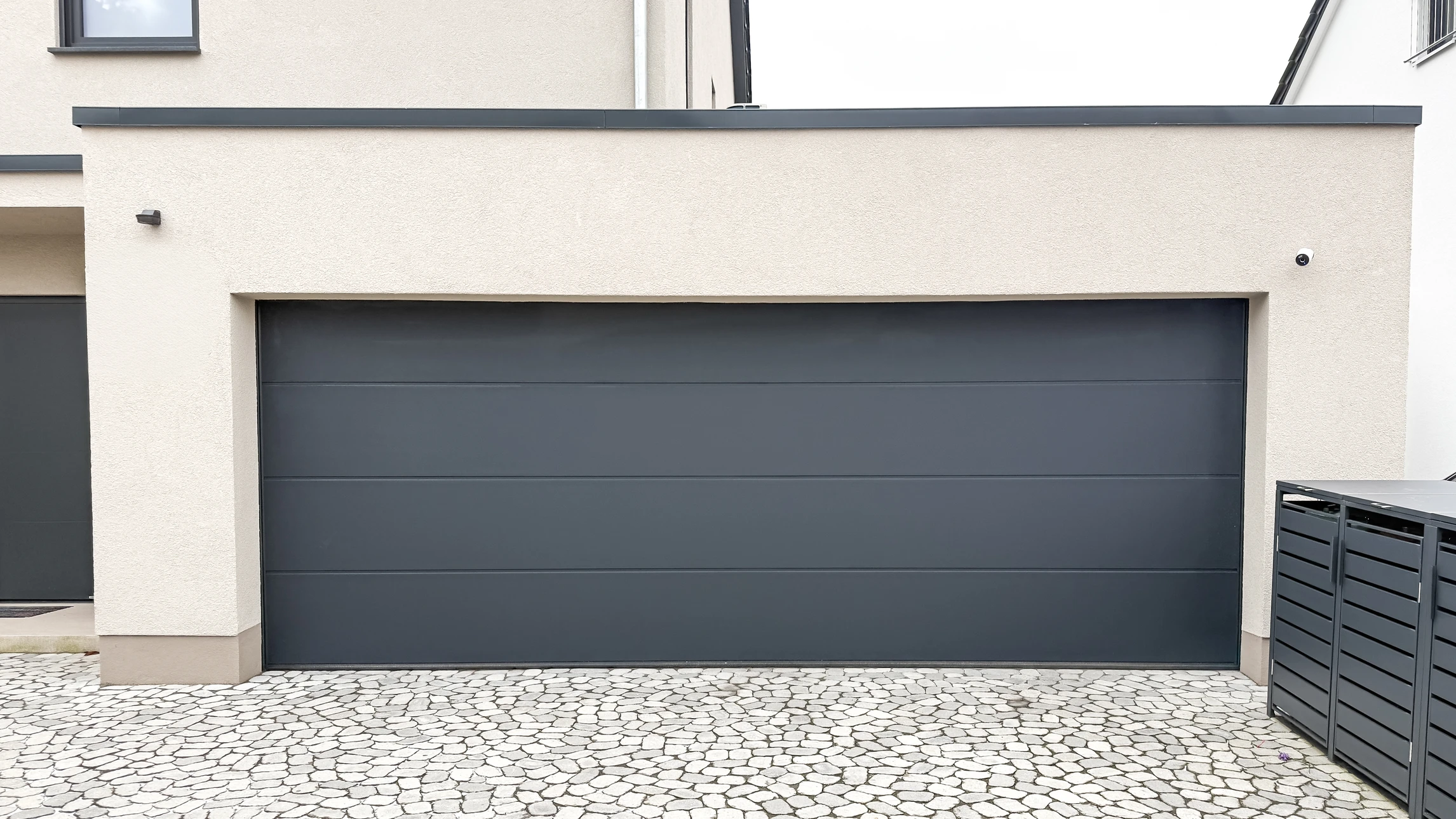 Deux techniciens en salopettes bleues et t-shirts orange installent une serrure de porte intérieure